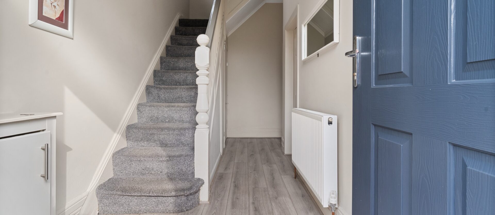Entrance hall and staircase with a blue front door at an Uptrend Estates property.